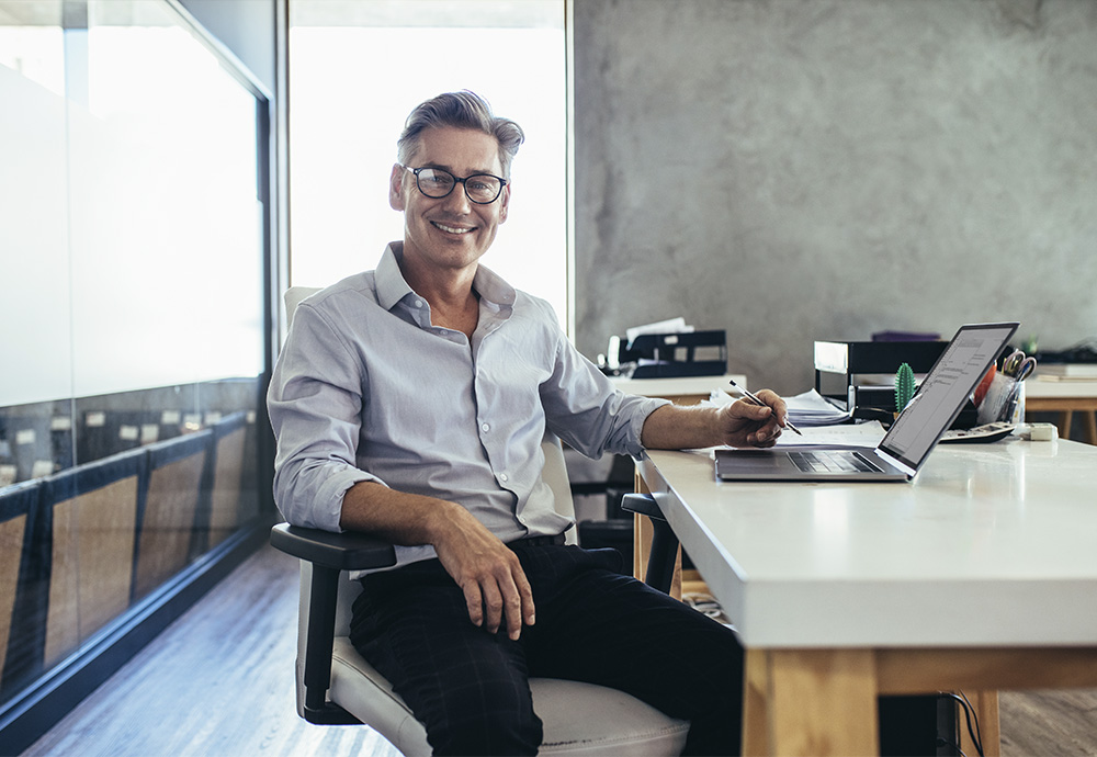 man at desk with laptop open